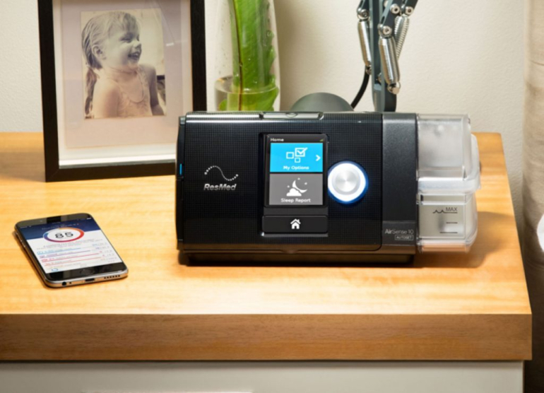 airsense 10 pictured bedside with phone that has sleep tracking app